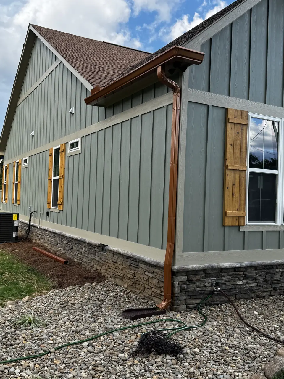 Copper-color gutters and downspout on a gable end