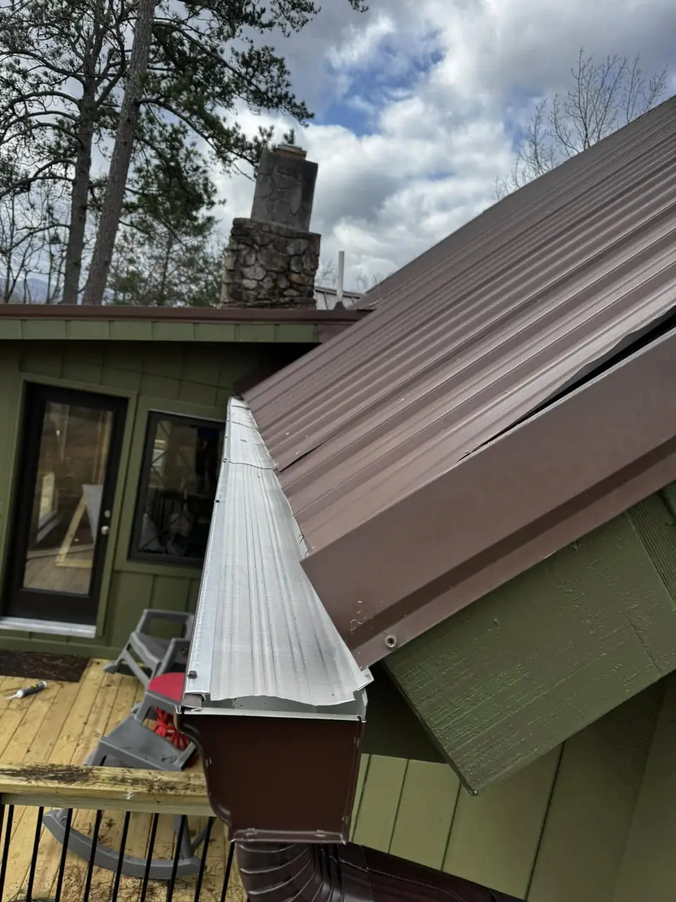 Gutter guard and downspout on a metal-roof home